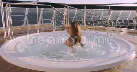 女士在豪华度假酒店的室外热水浴缸按摩浴缸中放松视频的预览图