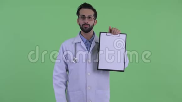 快乐的留胡子的波斯人医生展示剪贴板竖起大拇指视频的预览图