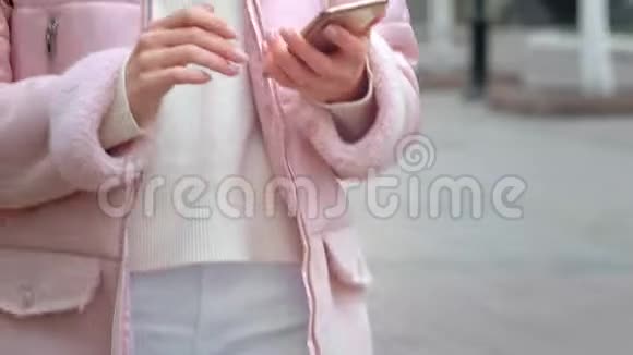 年轻漂亮的女孩在智能手机上打电话使用无线白色耳机打电话给朋友或亲戚视频的预览图