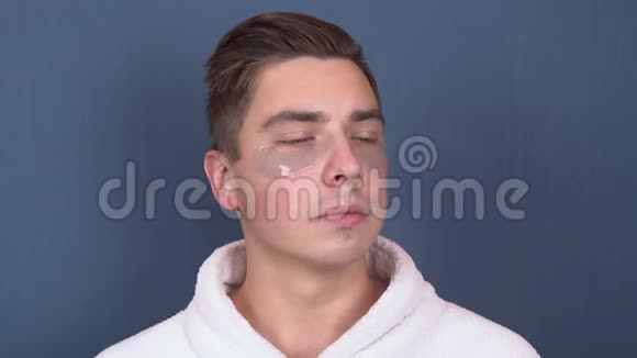 一个脸上有补丁的年轻人放松了水疗蓝色水凝胶贴片用于面部年轻化一个男人视频的预览图