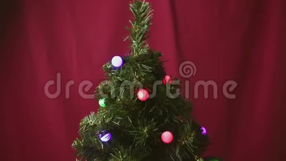 那个人手在圣诞树上挂着一个红色闪亮的球视频的预览图