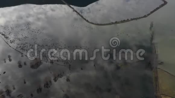 飞越希腊被洪水淹没的山谷被淹没的田野道路背景上的群山有人居住的定居点视频的预览图