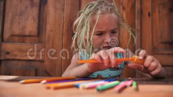 小六岁的女孩正在磨多种颜色的铅笔视频的预览图