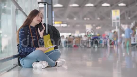 年轻的女性旅行者在等待某人时使用智能手机视频的预览图