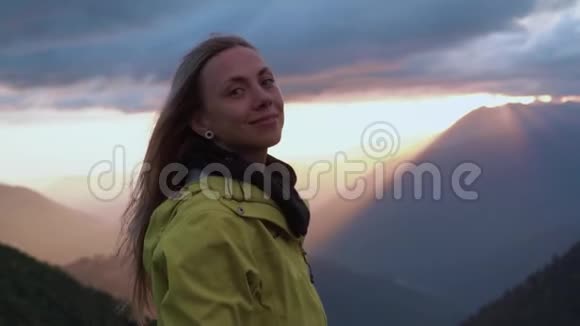 日落时一个女孩从山上欣赏风景那个女孩前景视频的预览图