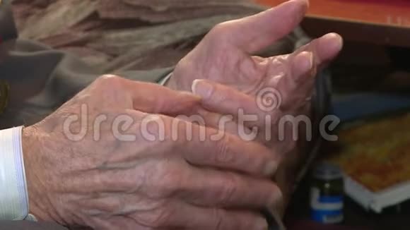 老人的特写双手随着皱纹的皮肤颤抖帕金森s病的概念视频的预览图
