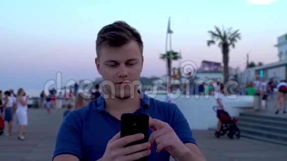 年轻的白种人欧洲游客做有趣的自我视频聊天与惊人的朗格伦海滩棕榈海滨的背景视频的预览图