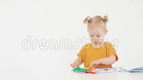 金发婴儿着色未知图片与多色蜡笔在白色背景视频的预览图