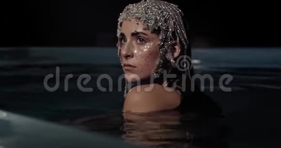 一个年轻漂亮的女人戴着一顶珠宝做的帽子现代艺术4K视频的预览图