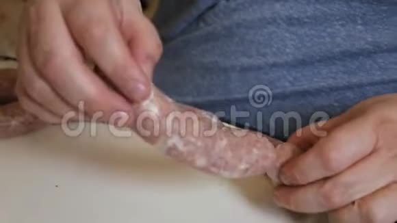一个男人用传统的方式用香肠填料煮香肠生牛肉香肠特写肉类生产视频的预览图