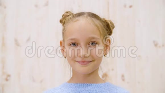 肖像快乐女孩少年微笑前镜头在灯光工作室背景特写脸满意的女孩看着视频的预览图
