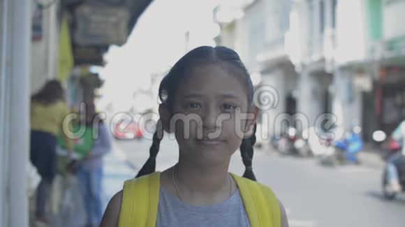 亚洲可爱女孩的肖像背包微笑站在老城镇普吉岛的小径上视频的预览图