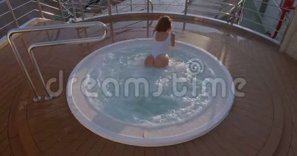 女士在豪华度假酒店的室外热水浴缸按摩浴缸中放松视频的预览图
