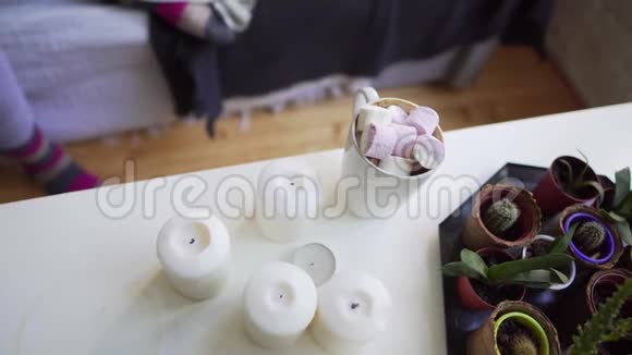 女孩从一张白色的桌子上拿着棉花糖喝热饮料平躺着视频的预览图