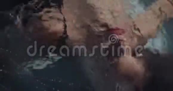 一位年轻女子在水下游泳的照片4k的俯视图视频的预览图