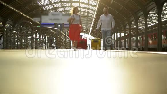 一对夫妇带着一个手提箱在火车站跑当火车离开时手里拿着护照的女人视频的预览图
