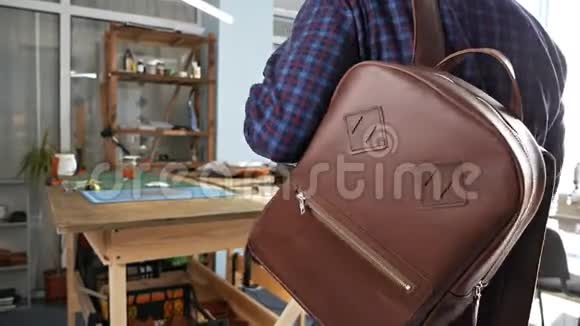一个男人试穿一个手工制作的皮革背包选择一个舒适的背包供日常使用皮革内饰视频的预览图