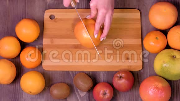女人手在厨房里切鲜橙色视频的预览图