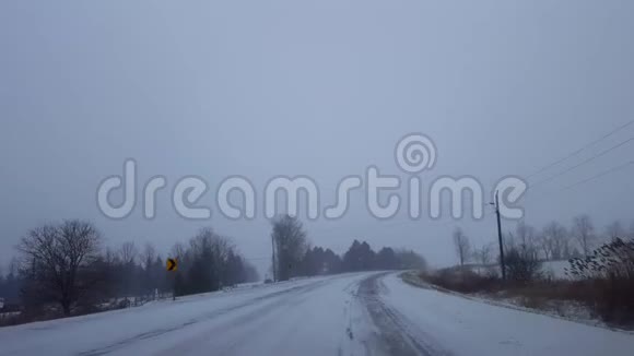 在冬季暴风雪中驾驶Uphill绕道弯曲司机视角POV雪雪暴雪视频的预览图
