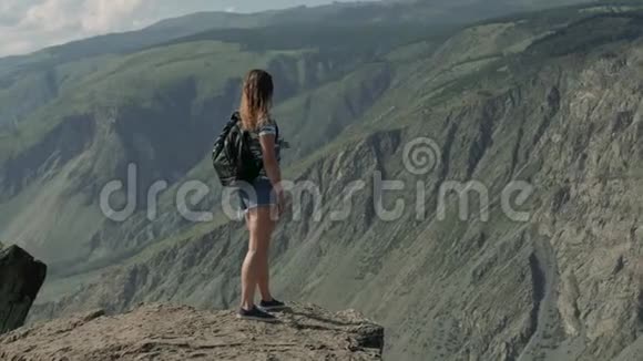 女旅行者站在山崖前眺望远方视频的预览图