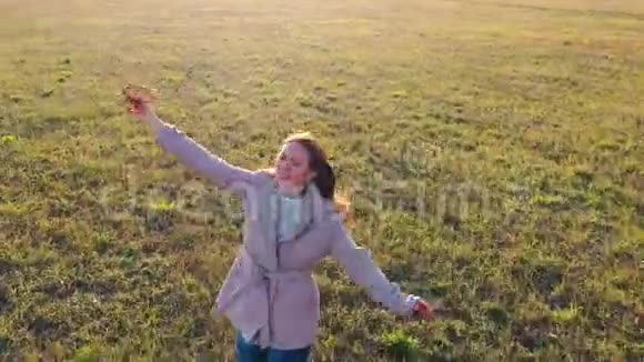 女孩跑过田野拿着飞机模拟飞行秋天晴朗的一天户外娱乐视频的预览图