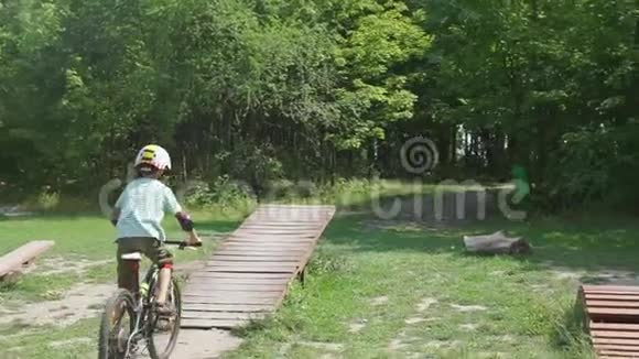 一个骑自行车的男孩在学校操场上骑着秋千障碍物视频的预览图