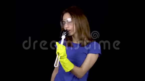 一个年轻的女人在马桶刷里唱歌就像在麦克风里一样戴安全眼镜和带清洁工具手套的女人视频的预览图