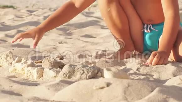 可爱的男孩在沙滩上玩石头视频的预览图