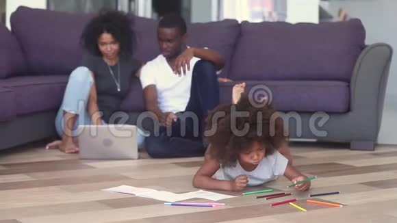 孩子用笔记本画父母花时间在加热地板上视频的预览图