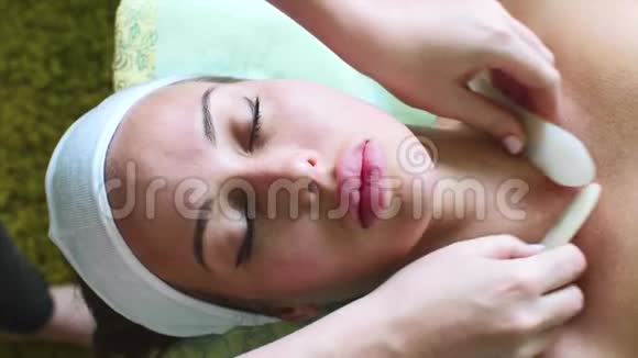 女性在美容水疗中心接受石蜡切片面部按摩视频的预览图