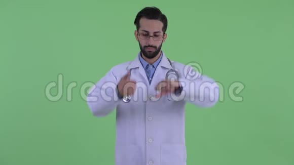 困惑的年轻留胡子的波斯人医生在竖起大拇指和竖起大拇指之间做出选择视频的预览图