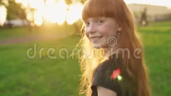 快乐的姜姑娘漫步在夏日公园里看着夕阳视频的预览图