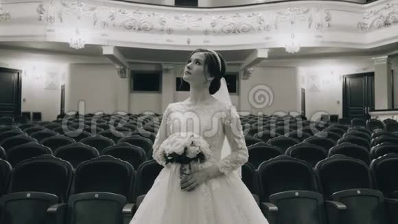 一个穿着雪白裙子的女孩站在歌剧院礼堂的中间照相机在动视频的预览图