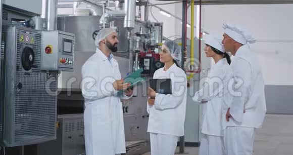 男工程师和他的助手在食品工业工厂开会他解释了指示和安全说明视频的预览图