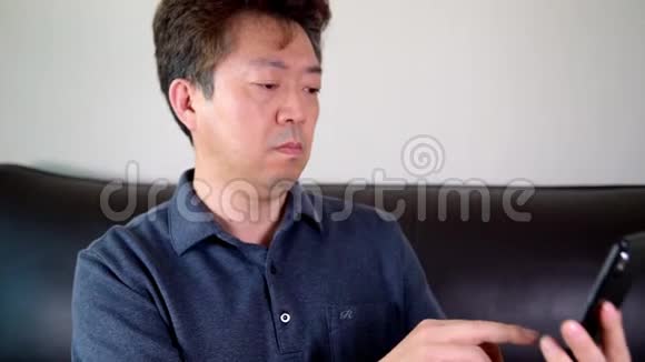 亚洲中年男性试图在手机上读到一些东西老花眼近视视频的预览图