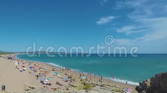 海滩上的岩石游客地中海时代视频的预览图