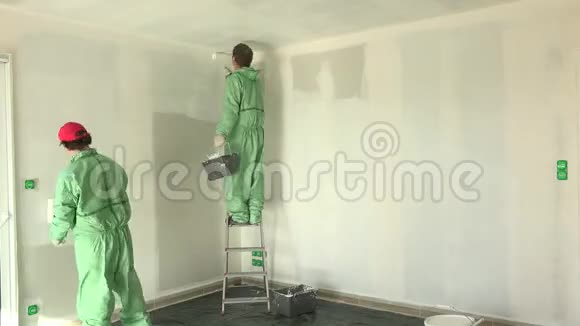 两位画家在新房子里画墙白和天花板视频的预览图