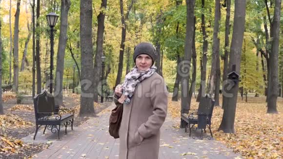 美丽的女人站在秋黄公园视频的预览图