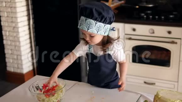 厨房里一个小女孩的肖像她用手吃蔬菜视频的预览图