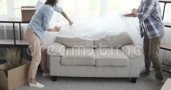 幸福的一对夫妻在新房子里摔在沙发上视频的预览图
