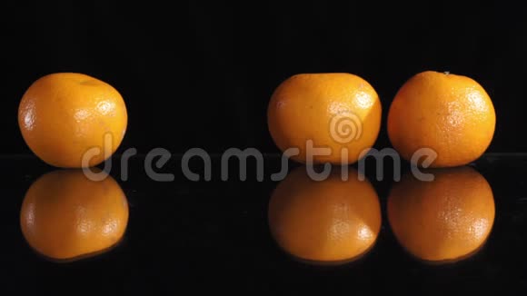 黑色背景下的一排柑橘类水果玻璃表面的反射视频的预览图