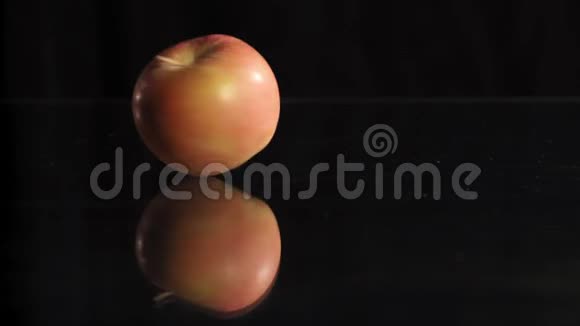 在玻璃表面旋转红苹果低键暗背景视频的预览图