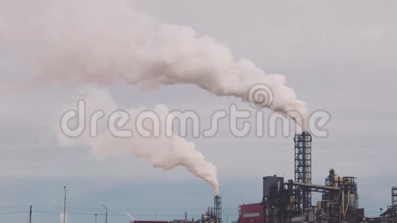 工业区用一根管道冒厚的白烟与太阳形成对比从工厂管道中倒出污染视频的预览图