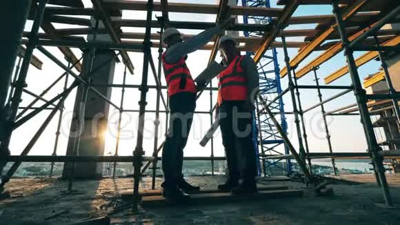在未完工的建筑里穿制服的工人站着视频的预览图