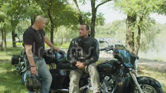 积极的男性骑自行车者在摩托车附近聊天视频的预览图
