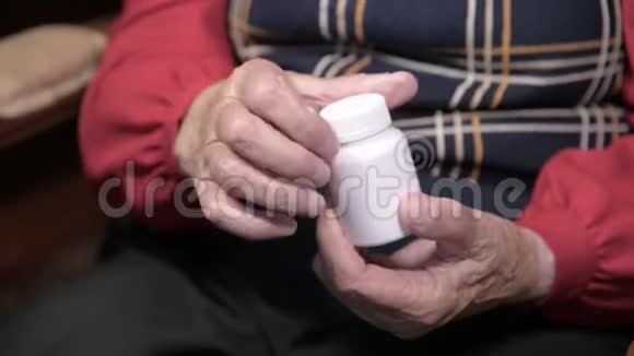 一位老妇人的手打开一个白色罐子里面有欧米茄3药物胶囊和维生素健康概念补充剂视频的预览图