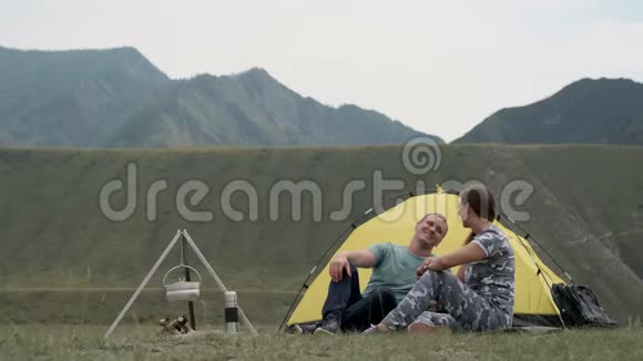 可爱的夫妇在帐篷前自然放松男人和女孩在工作接吻视频的预览图