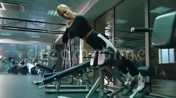 漂亮的女孩在健身房锻炼侧视视频的预览图