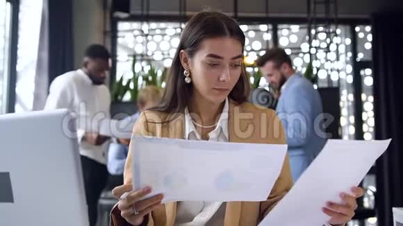 可爱的有目标的年轻女商人在现代办公室的电脑屏幕上喜出望外视频的预览图