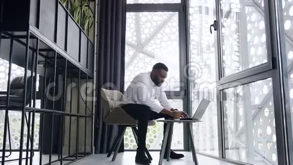 美国黑人办公室工作人员在现代办公室的一个独立的地方用大胡子在电脑上打字视频的预览图